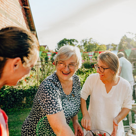 Seniorin und zwei weitere Frauen im Garten