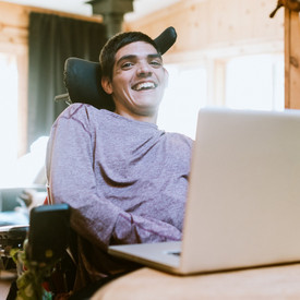 Teilhabe am Arbeitsleben Ein Mann im Rollstuhl arbeitet am Laptop
