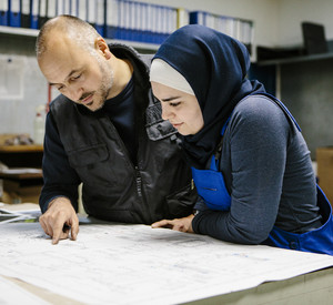 Zwei Techniker besprechen einen Plan Zwei Techniker besprechen den Plan für eine Maschine