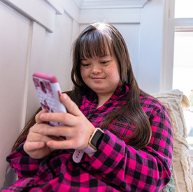 Digitale Barrierefreiheit Eine Frau mit Down Syndrom benutzt ein Smartphone