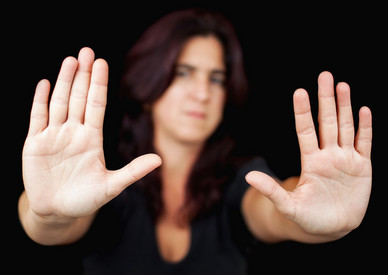 Gewalt gegen Frauen und Mädchen Symbolbild RIGG: eine Frau mit ausgesteckten Armen und erhobenen Händen: "Halt, stopp!"