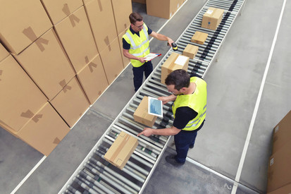 Zwei Arbeiter in einem Lager in der Logistikbranche, der Pakete am Fließband verarbeitet